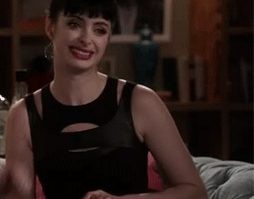 GIF chica sentada en el sofá moviendo la cabeza afirmando algo