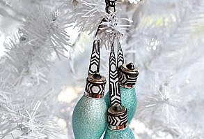 Reinvent+old+light+bulbs+as+tree+ornaments+by+spray-painting+them+with+metallic+paint,+then+grouping+together+in+clusters+with+ribbon.+Smaller+light+bulbs+work+best+grouped+in+odd+numbers,+while+larger+lightbulbs+are+best+as+single+ornaments.